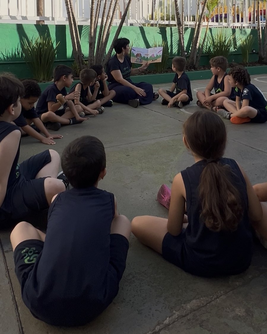Professora lendo para a turma em roda, na aula de socioemocional