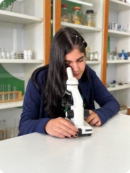 Aluna observando no microscópio